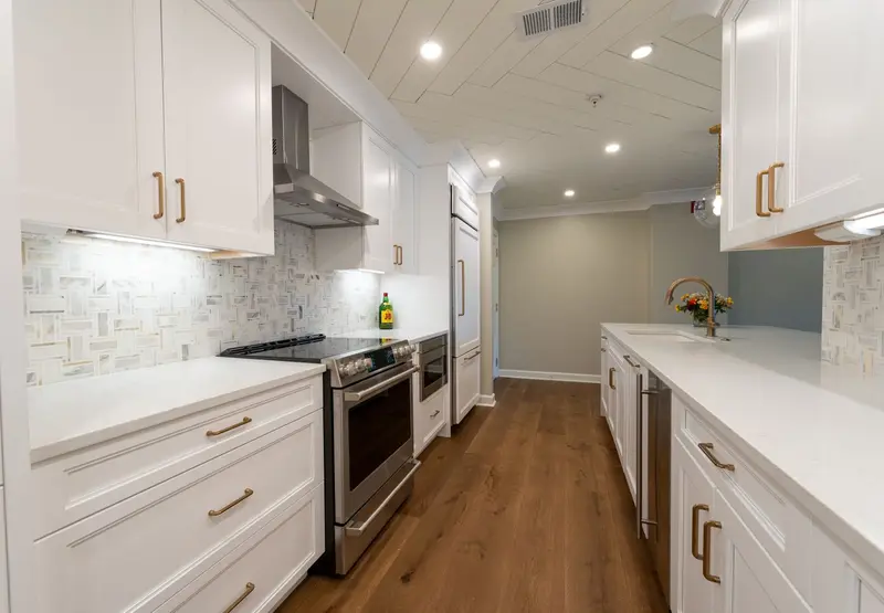 Bright white kitchen with new counters and wood flooring